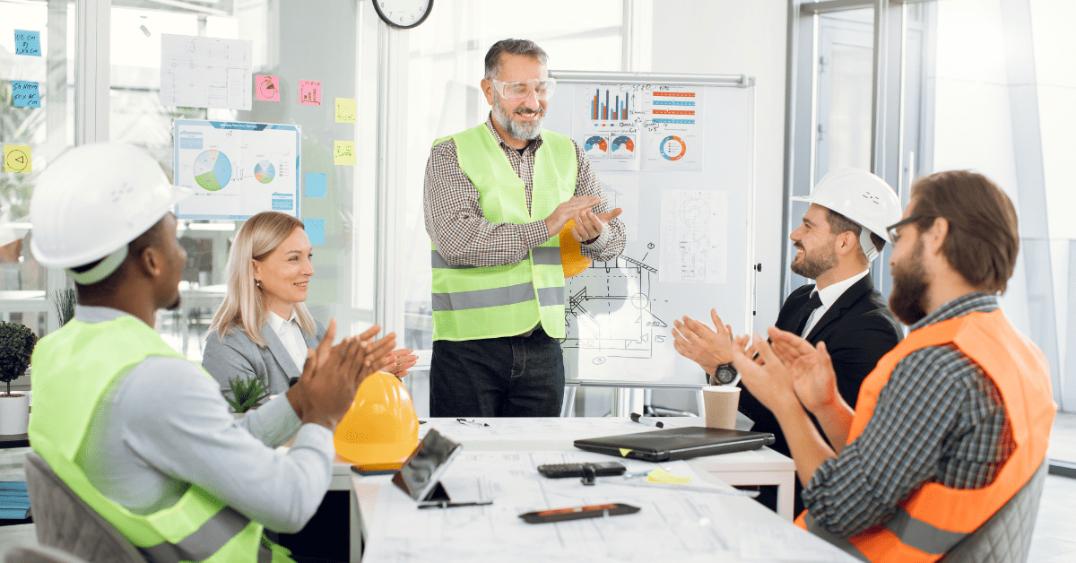 Multigenerational team, with four employees watching another employee present