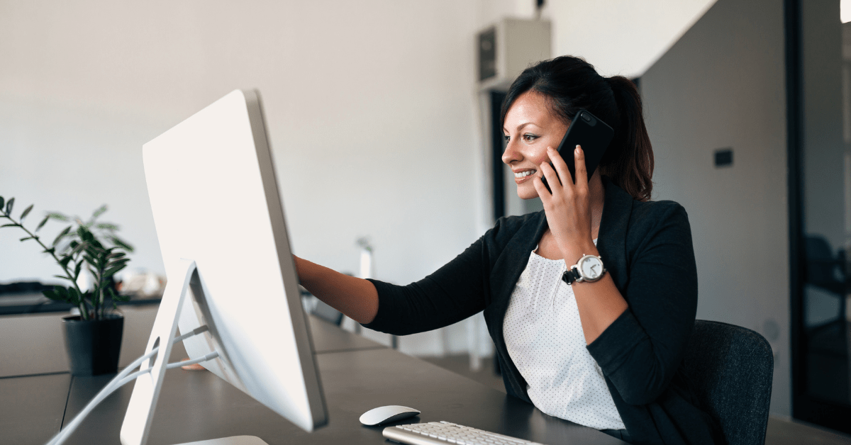 Administrative employee talking on the phone and looking at computer